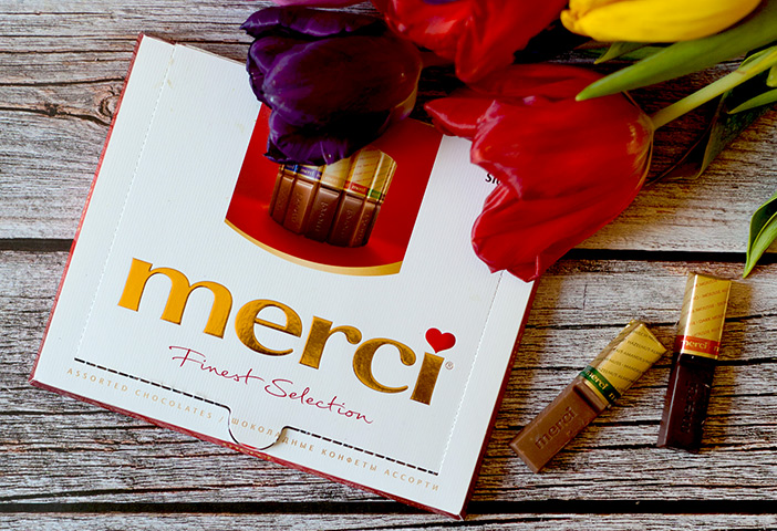 Mehrere Tulpen liegen auf einem Tisch mit einem merci