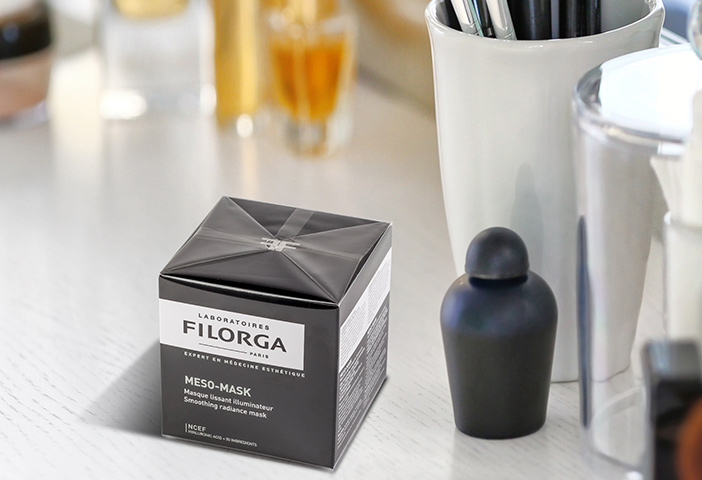 Eine Kosmetikmaske mit Pinsel stehen auf einem Tisch