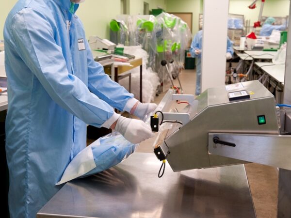 Ein Mann verschweißt mit einem Folienschweißgerät eine Sterilgutverpackung