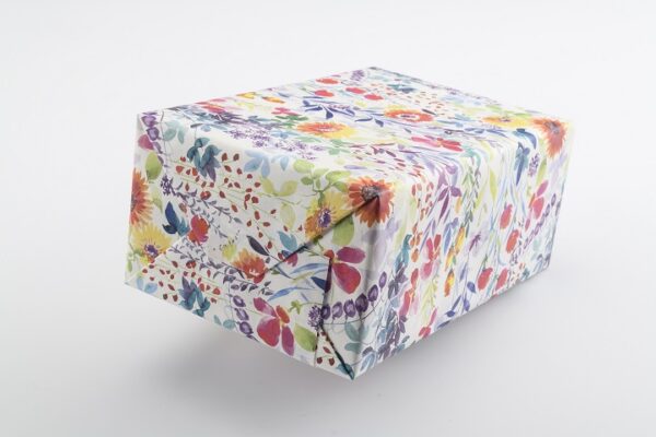 Ein Geschenk mit bunter Blumenverpackung als Verpackungsmuster für Falteinschlag