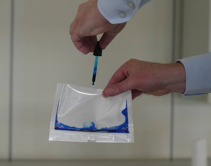 Tintentest wird mit einer Pipette in eine Verpackung getropft zur Prüfung der Nahtintegrität