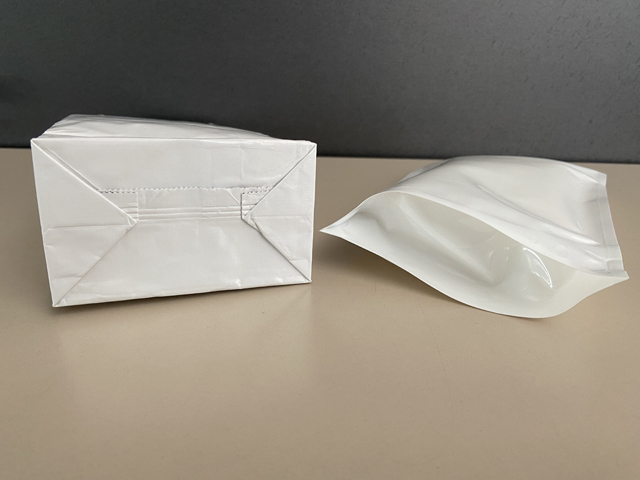 Ein Blockbodenbeutel und ein Doypackbeutel liegen auf einem Tisch